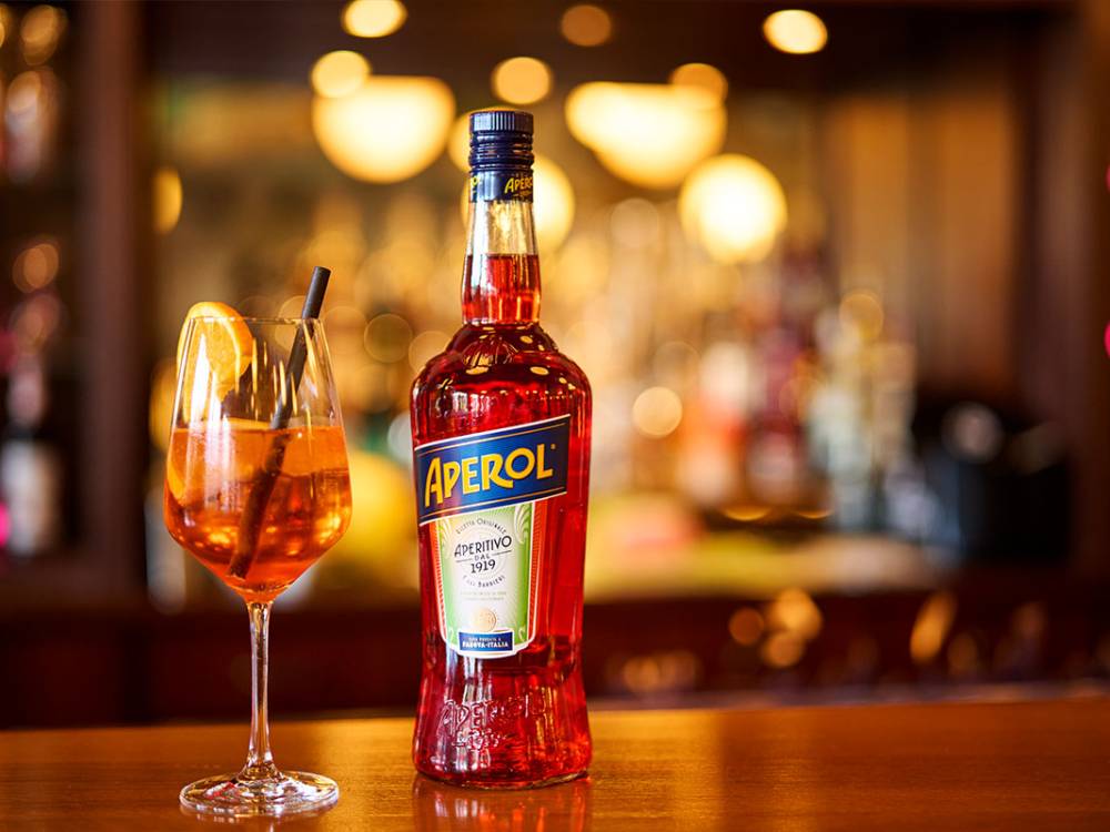 Ein Glas Aperol Spritz und eine Aperolflasche auf der Bartheke im Zinnowitzer Hof von Schöner Inseln auf Usedom.