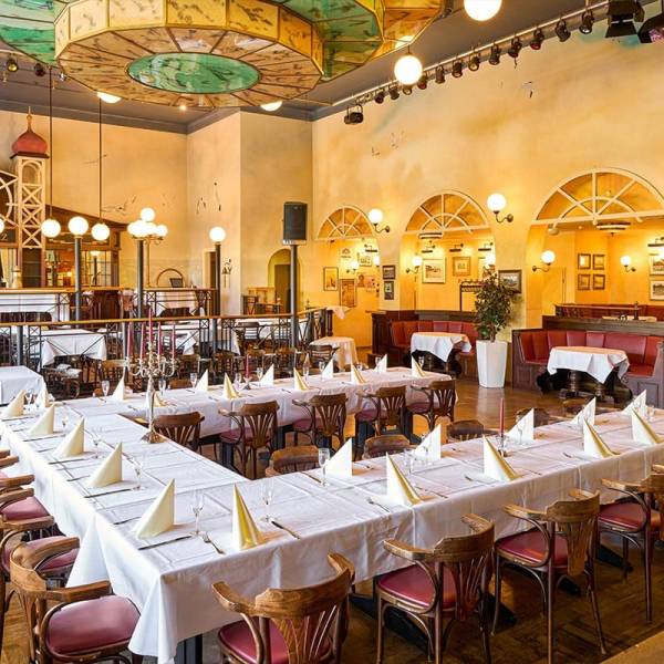 Historischer Festsaal mit langer Tafel, weißer Tischwäsche, Kronleuchtern und nostalgischem Dekor für Veranstaltungen auf Usedom.