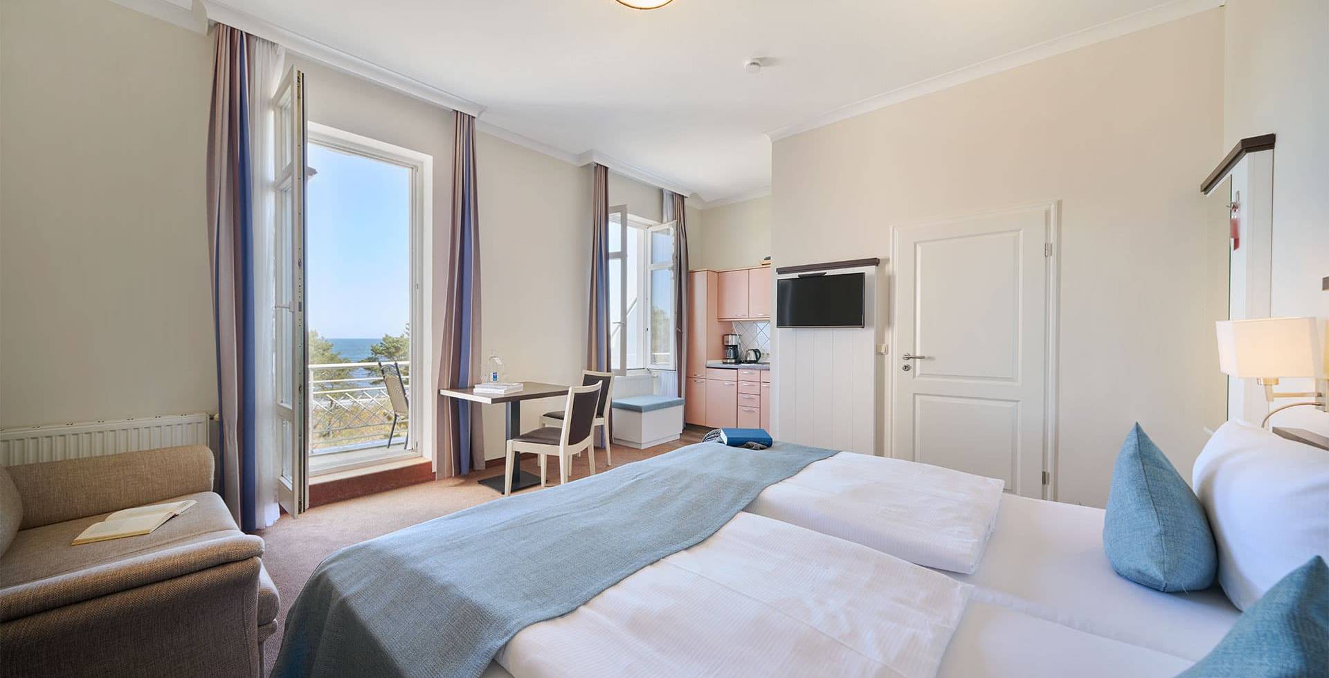 Helles Studio Apartment mit Doppelbett, Sofa, Küchenzeile und Meerblick vom Balkon im Strandpalais in Zinnowitz.