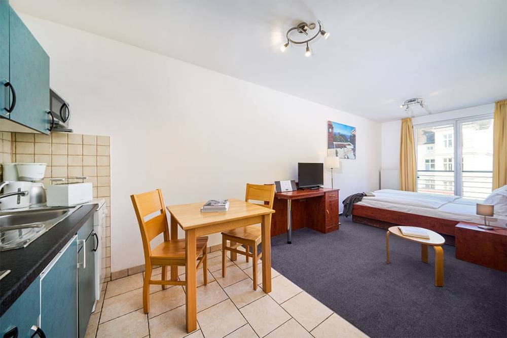 Ferienappartement in Zinnowitz auf Usedom mit gemütlichem Schlafbereich, kleiner Küche und hellem Wohnbereich.