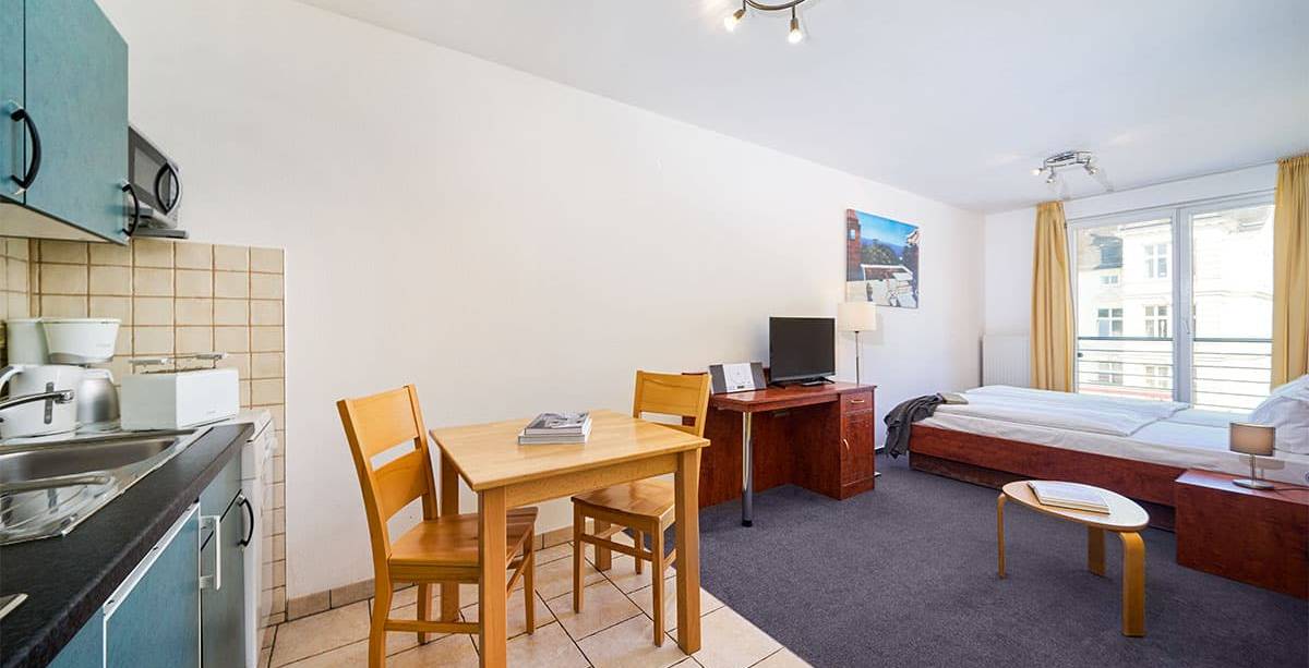 Ferienappartement in Zinnowitz auf Usedom mit gemütlichem Schlafbereich, kleiner Küche und hellem Wohnbereich.