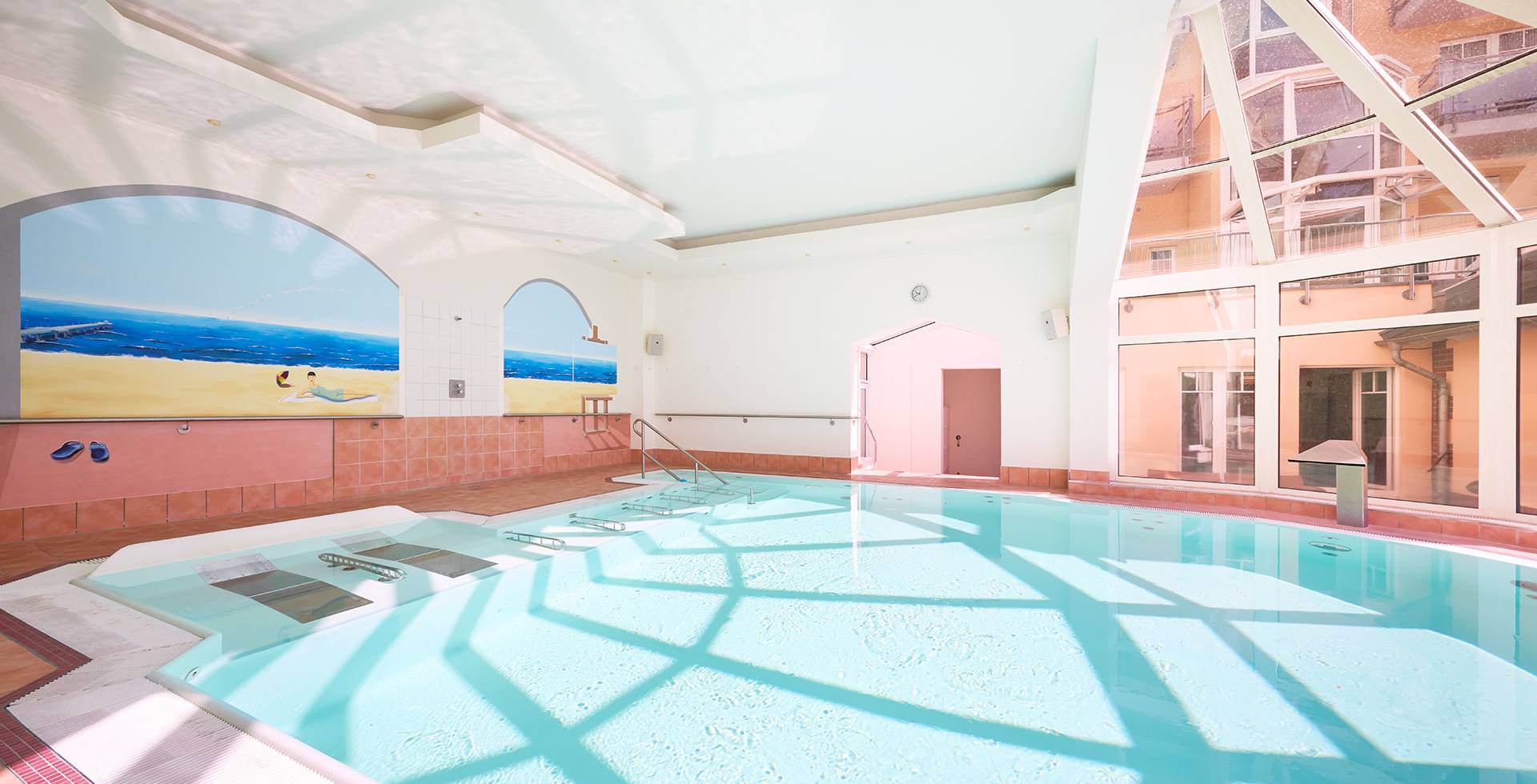Heller Indoorpool mit großen Fensterfronten und Wandmalereien im Preussen-Vital-Spa in Zinnowitz auf Usedom.