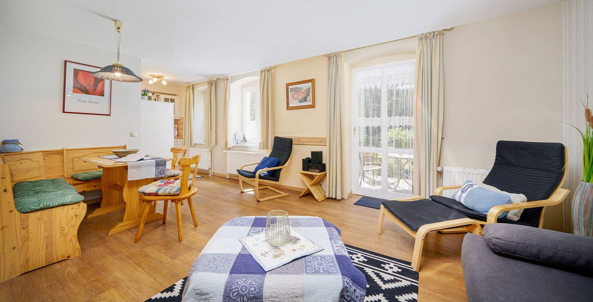 Wohnbereich mit Sitzecke, Esstisch und viel Tageslicht in der Juniorsuite zur Landseite auf Usedom.