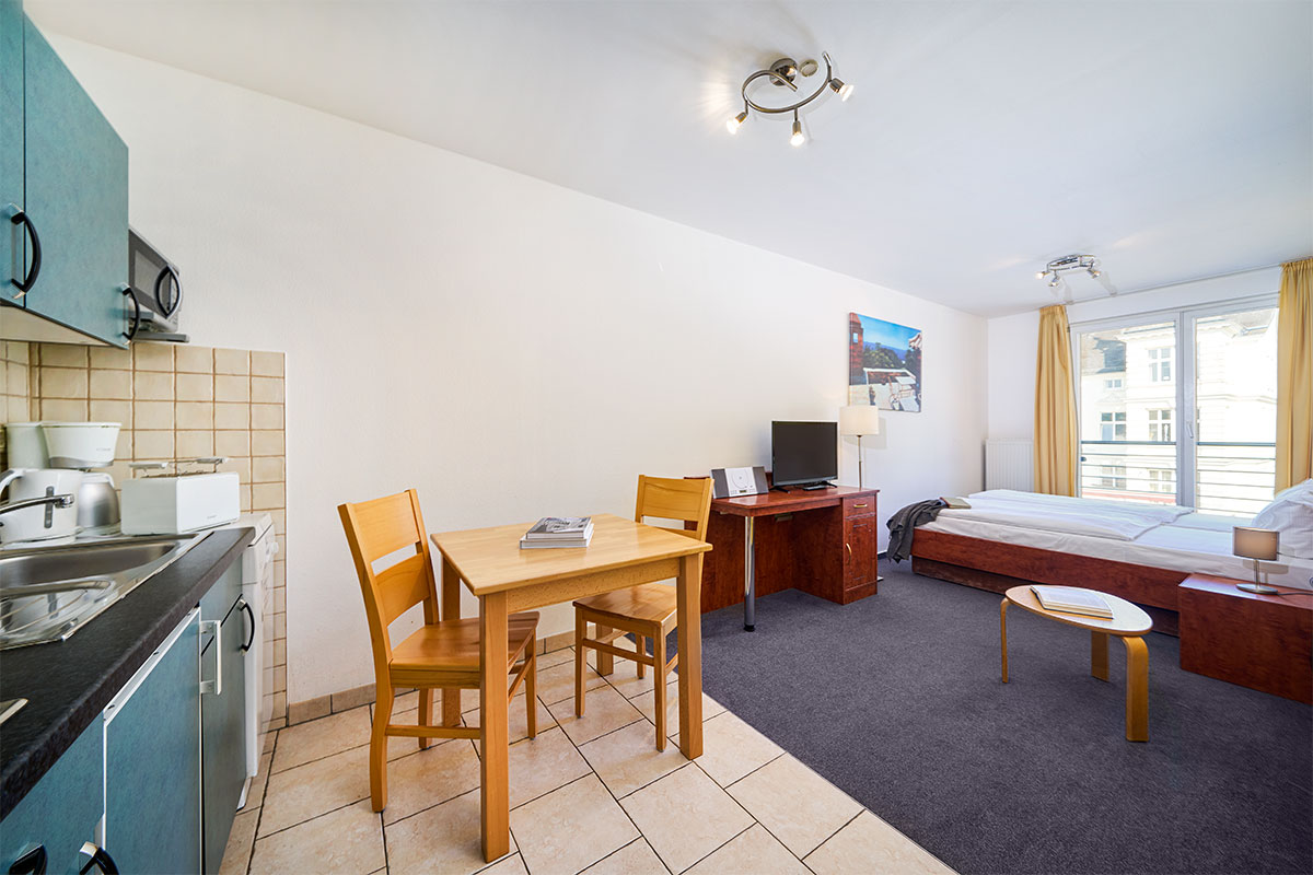 Ein-Raum-Appartement in Zinnowitz auf Usedom mit gemütlichem Schlafbereich, kleiner Küche und hellem Wohnbereich.