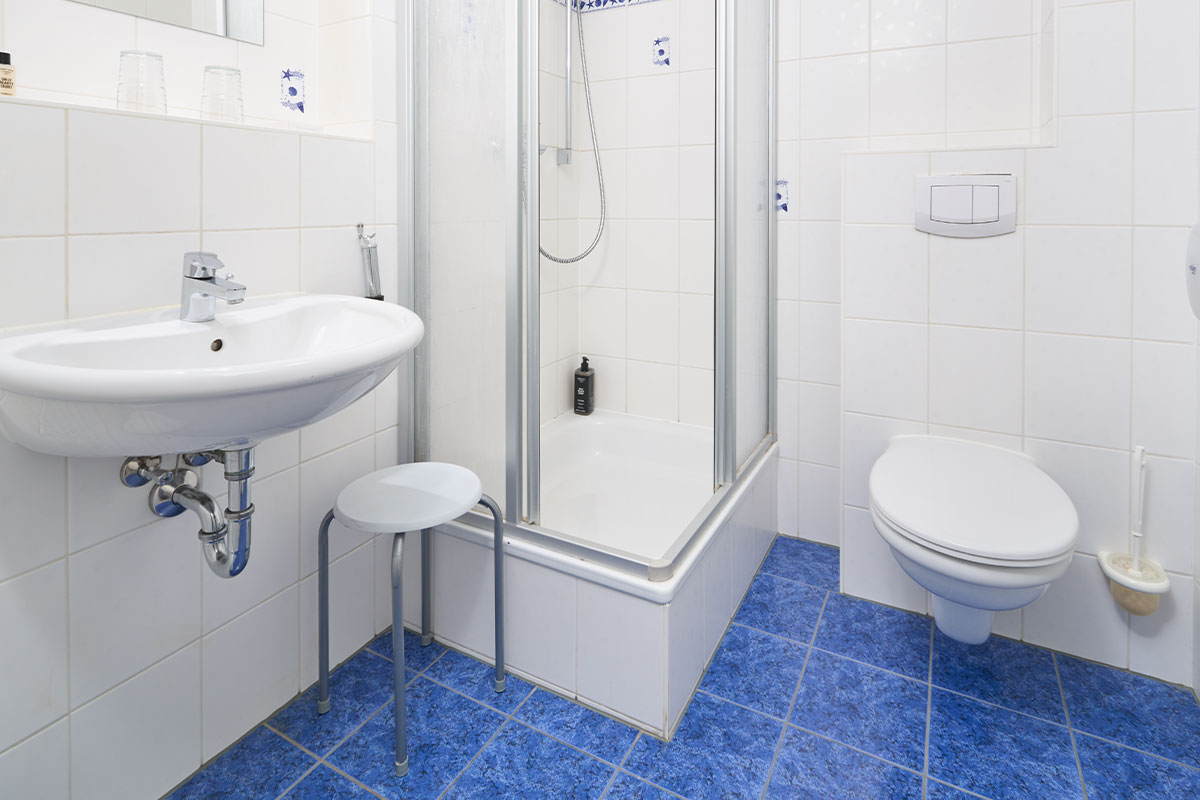 Modernes Badezimmer in einem Ein-Raum-Appartement in Zinnowitz mit Dusche, Waschbecken und zeitloser Ausstattung.