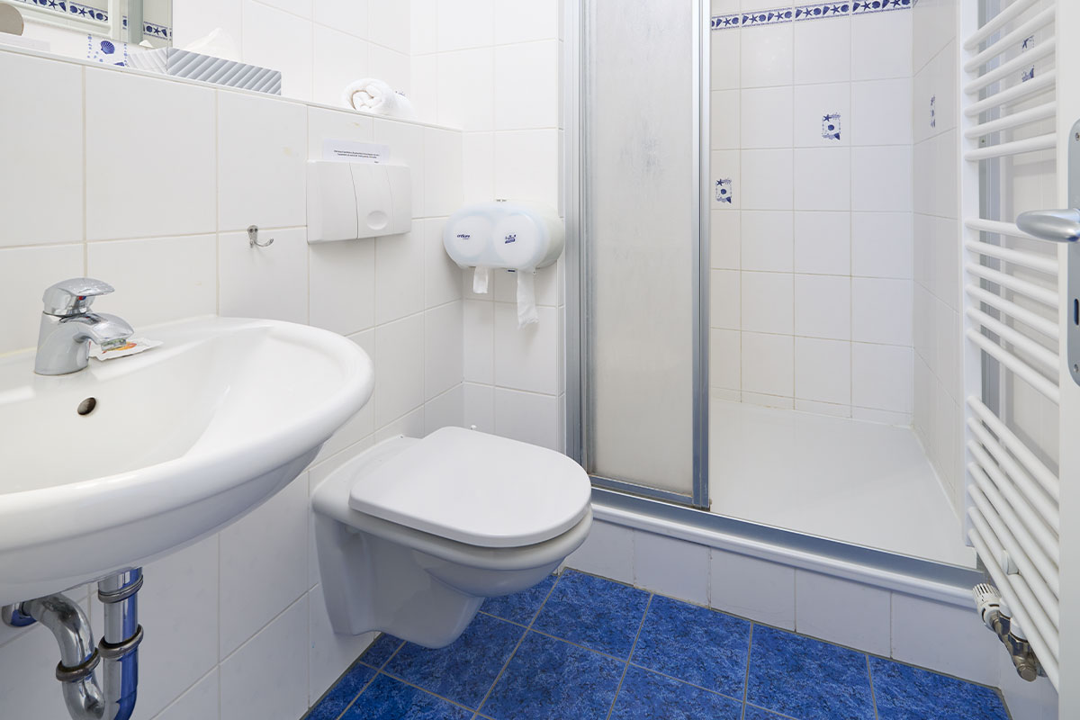 Helles Bad mit Dusche, WC und Waschbecken in den Ferienwohnungen der Strandperle auf Usedom.
