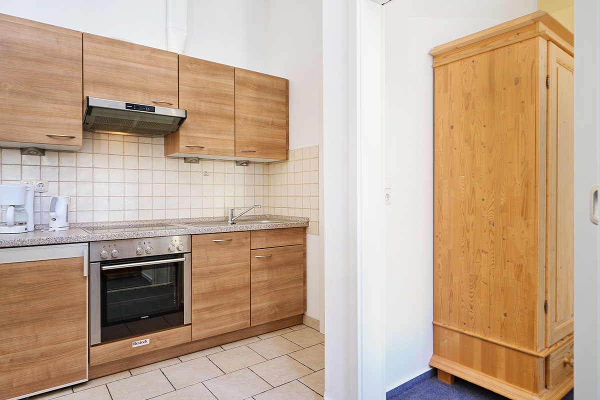 Helle Ferienwohnungsküche mit Holzfronten und modernen Geräten im Appartement der Schöner Inseln auf Usedom.