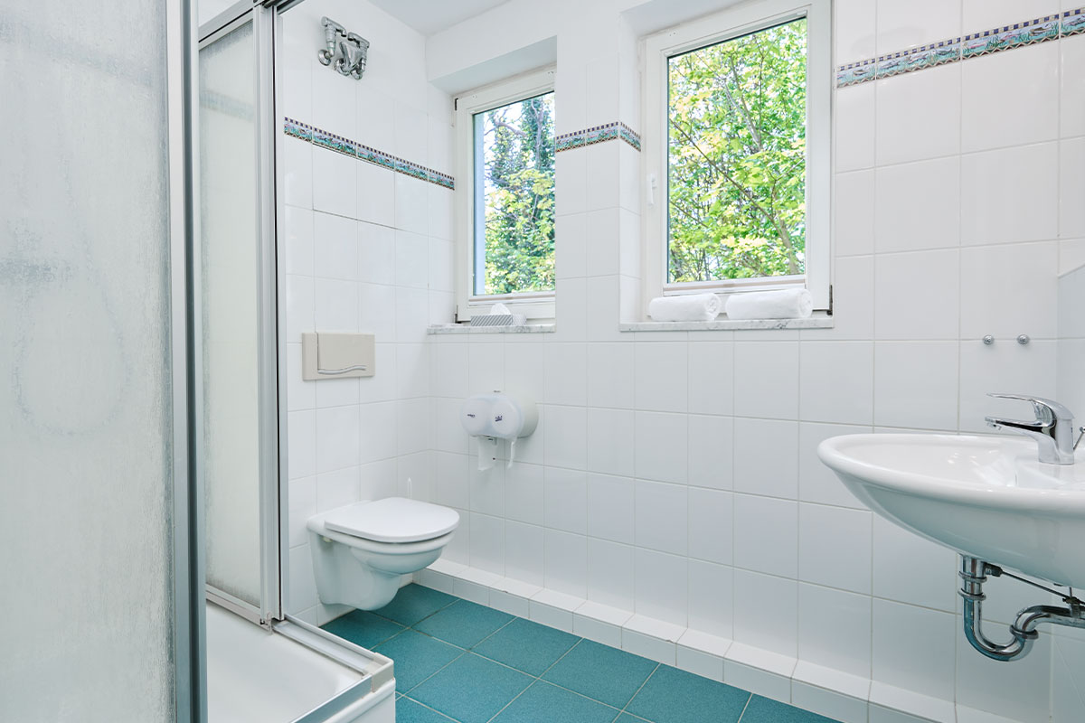 Modernes Badezimmer in einem Zwei-Raum-Appartement in Zinnowitz mit Dusche, Waschbecken und zeitloser Ausstattung.