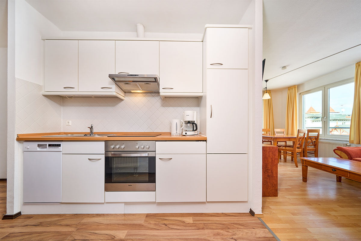 Helle Einbauküche mit Backofen, Spülmaschine und Kaffeemaschine in den Ferienwohnungen der Schöner Inseln auf Usedom.