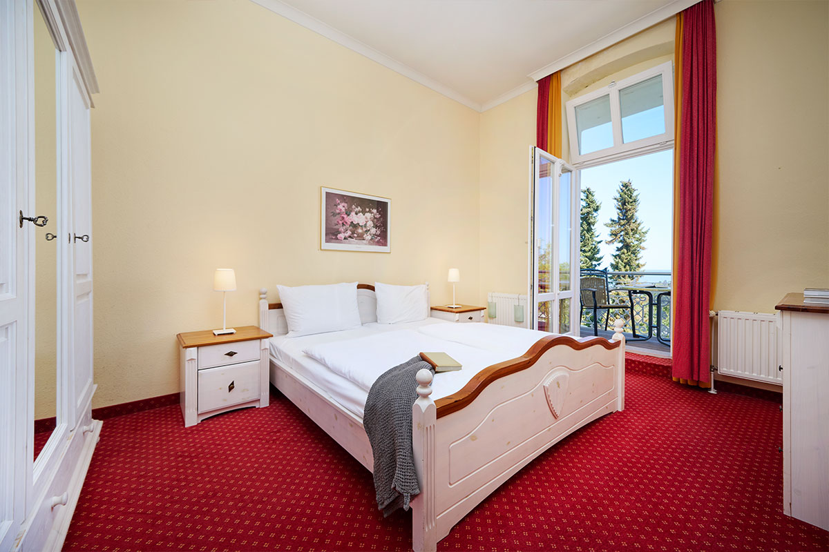 Schlafzimmer mit Doppelbett, Balkon und Meerblick in einer stilvollen Ferienwohnung in Zinnowitz auf Usedom.