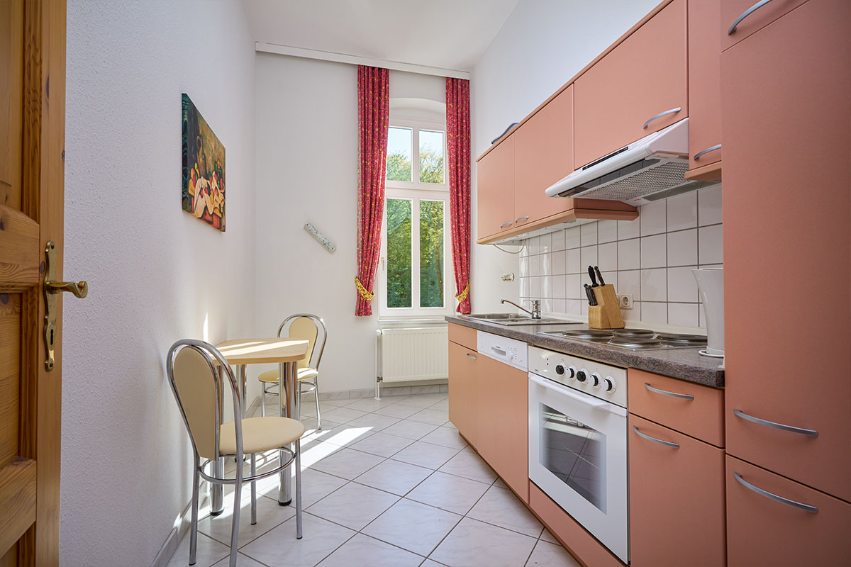 Küche mit kleinem Esstisch und Tageslicht in einer 2-Raum-Ferienwohnung in Zinnowitz auf der Ostseeinsel Usedom.