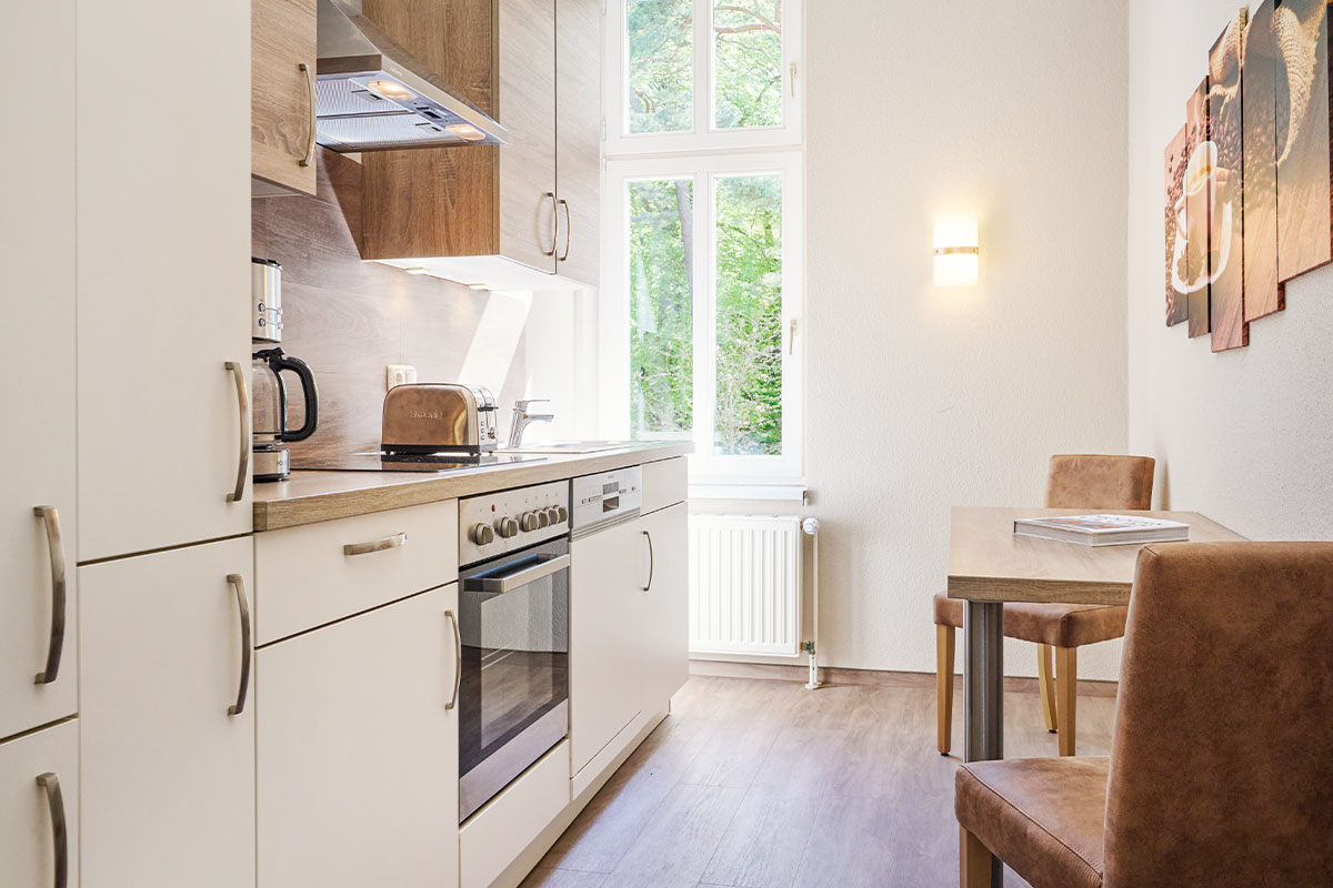 Küche mit Einbauzeile, Fenster und kleinem Esstisch in der Familiensuite zur Meerseite auf Usedom.