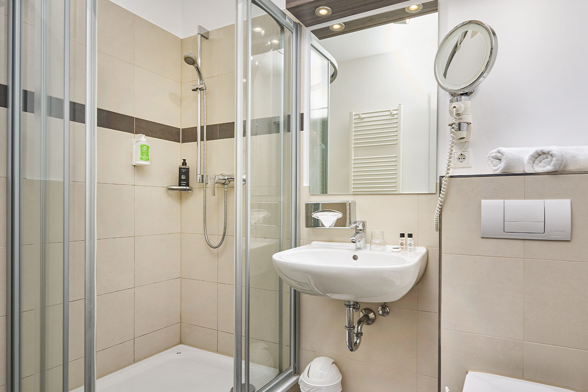 Modernes Bad mit Dusche, Waschbecken und Kosmetikspiegel in der Juniorsuite auf Usedom.