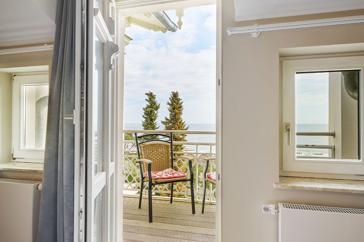 Blick vom Schlafzimmerbalkon der Juniorsuite auf zwei Stühle und die Ostsee.