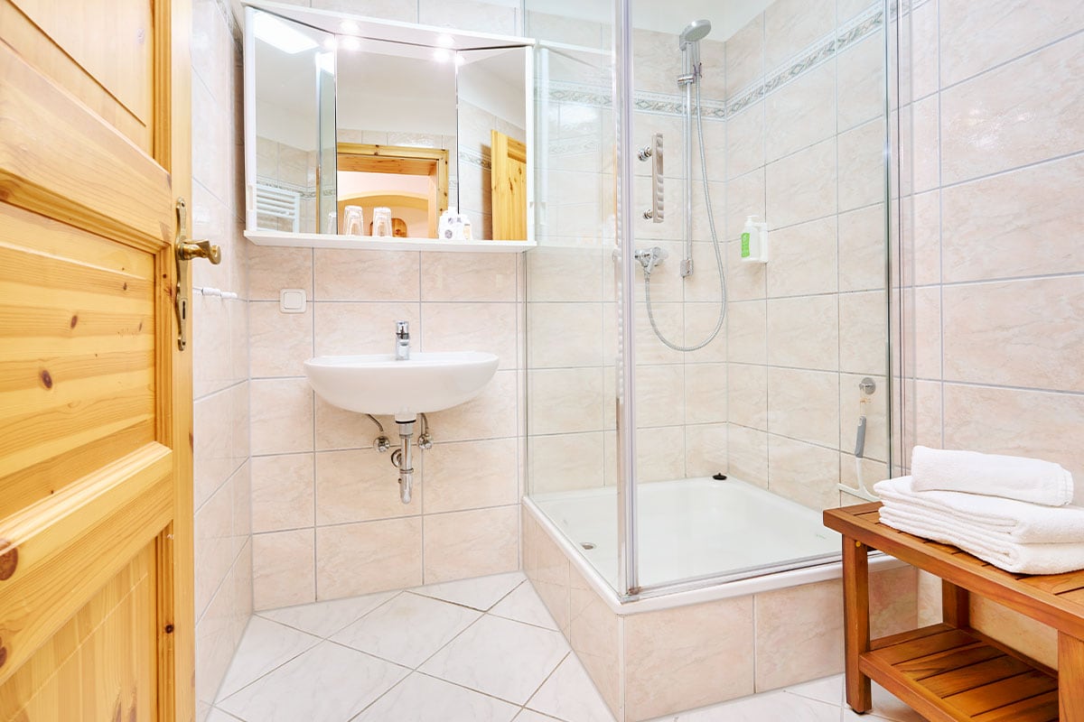 Badezimmer mit Dusche, Waschbecken und Handtüchern in der Juniorsuite der Strandvillen Wald und See.