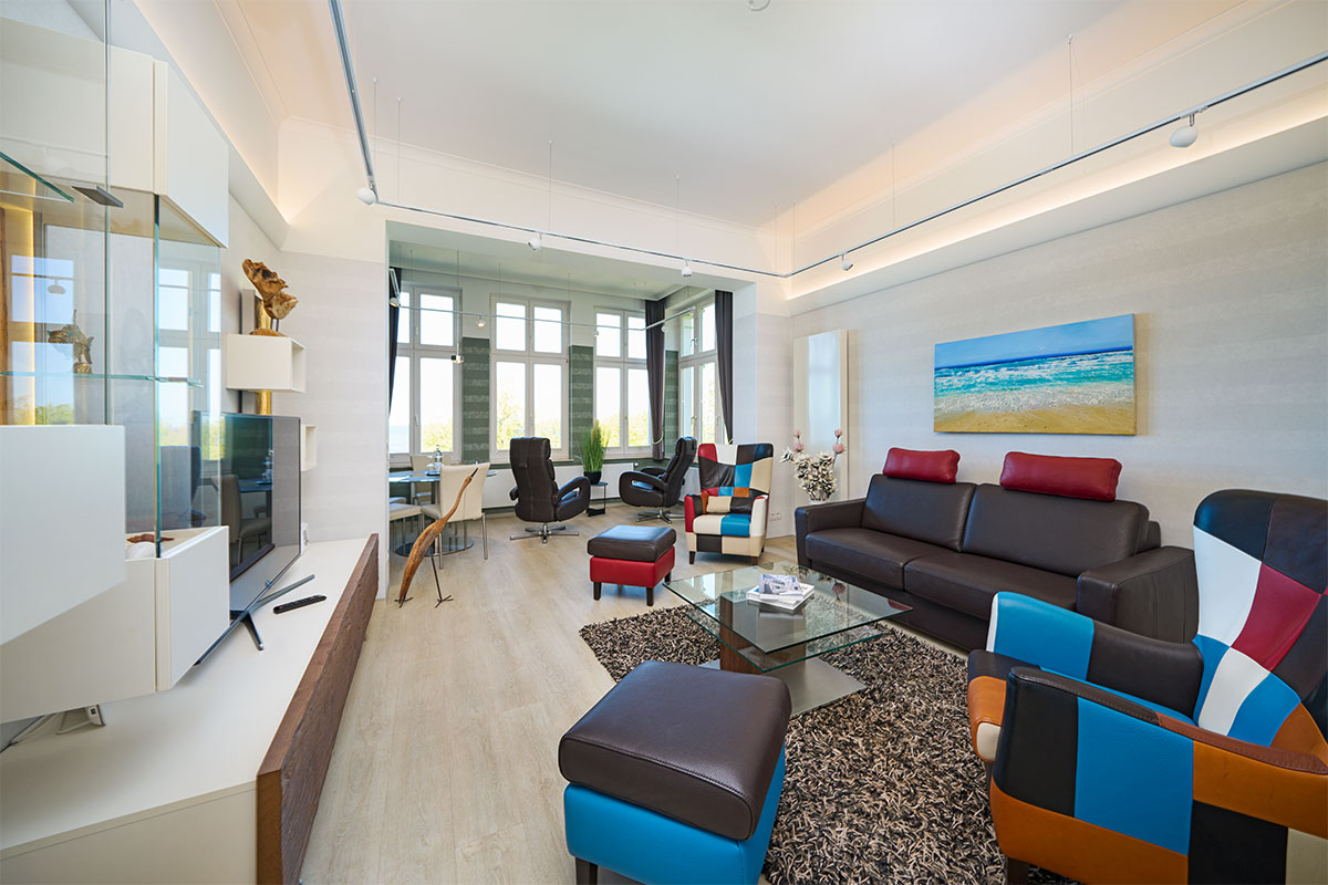 Wohnbereich mit Designermöbeln, Ledersofa und Blick ins Panorama der Ostsee Deluxe Suite auf Usedom.