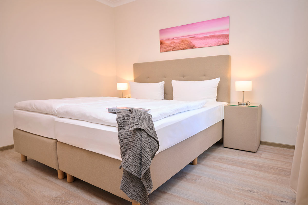 Helles Schlafzimmer mit gemütlichem Doppelbett in der Ferienwohnung Zinnowitzer Hof auf Usedom.