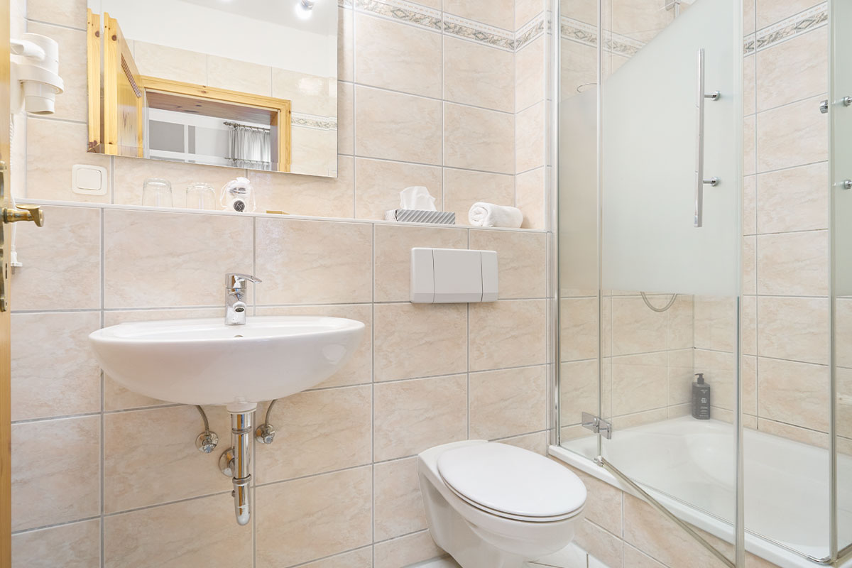 Helles Badezimmer mit Dusche, Waschbecken und WC in einem Appartement im Zinnowitzer Hof auf Usedom.