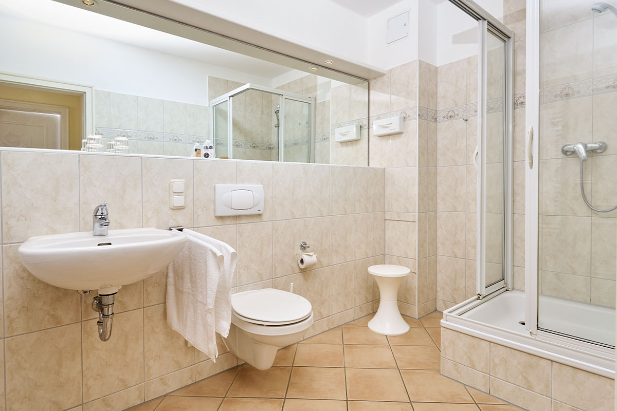 Modernes Badezimmer im Economy Apartment des Strandhotel Luise mit Dusche, Waschbecken und WC auf Usedom.