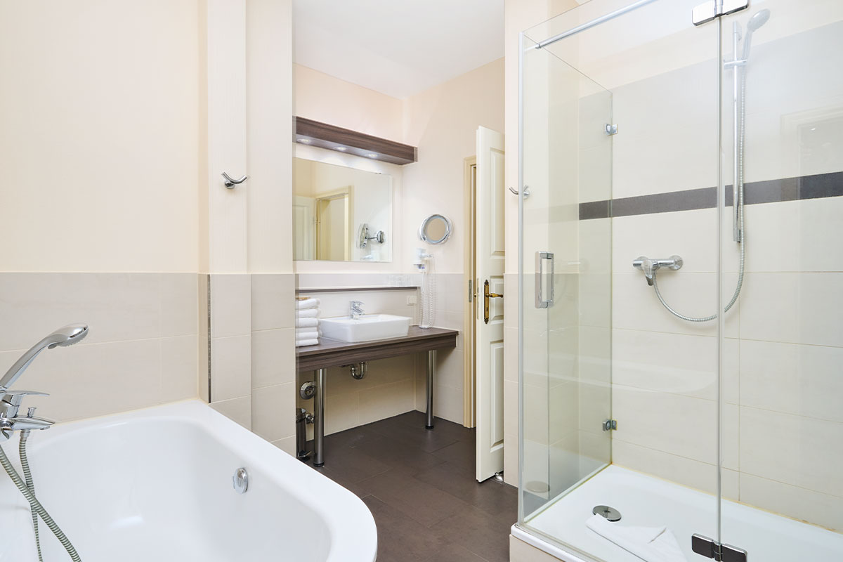 Badezimmer der Family Suite im Strandhotel Preußenhof mit Dusche, Badewanne und Waschtisch.