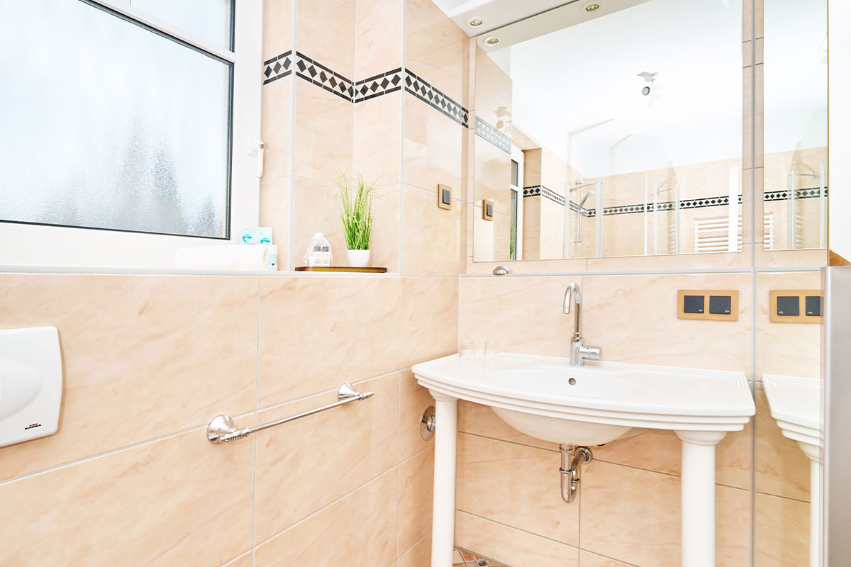 Modernes Waschbecken mit Spiegel im hell gefliesten Badezimmer der Penthouse-Suite im Strandhotel Prinz von Preussen.