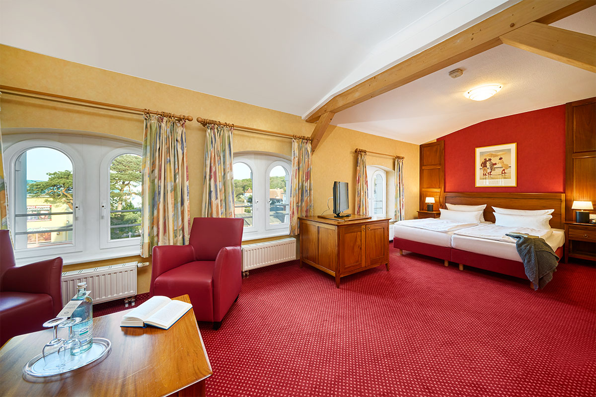 Großes Doppelzimmer Promenade mit Sitzecke, TV, zwei Einzelbetten und drei Fenstern in der Strandvilla Viktoria auf Usedom.
