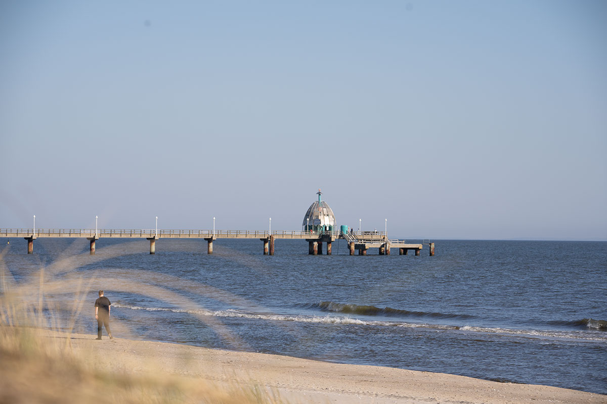 Blick auf die Tauchgondel an der Ostsee mit langem Steg und ruhigem Sandstrand vor dem Haus Strandperle von Schöner Inseln.