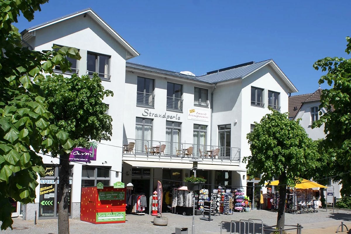 Außenansicht der Strandperle mit Balkonen und Geschäften, zentrale Ferienwohnungen, Partner von Schöner Inseln Zinnowitz.
