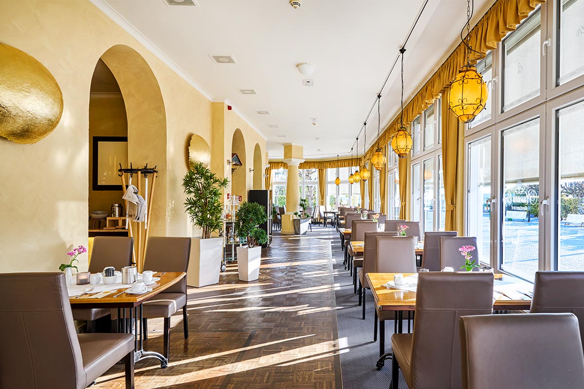 Heller Innenraum des Restaurants Lineti mit Fenstern, Vorhängen und gedeckten Tischen für kulinarischen Genuss auf Usedom.