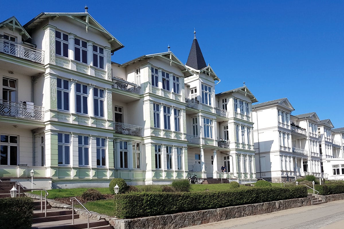 Mehrstöckige Strandvillen Wald&See von Schöner Inseln auf Usedom mit Balkonen und grüner Fassade im Stil der Bäderarchitektur.