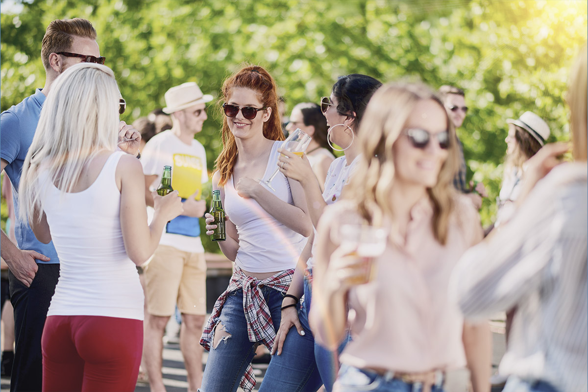 Freunde treffen sich mit kühlen Drinks bei einem musikalischen Event im Frühling