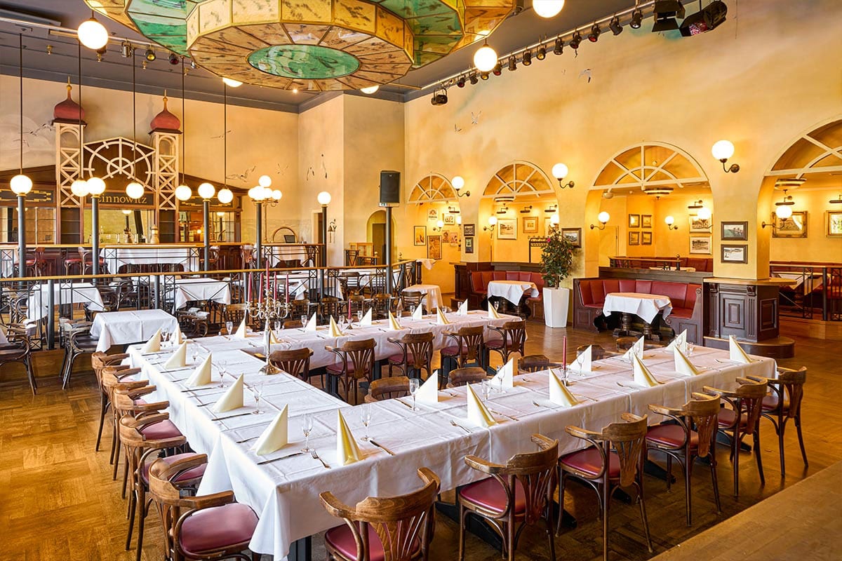 Historischer Festsaal mit langer Tafel, weißer Tischwäsche, Kronleuchtern und nostalgischem Dekor für Veranstaltungen auf Usedom.