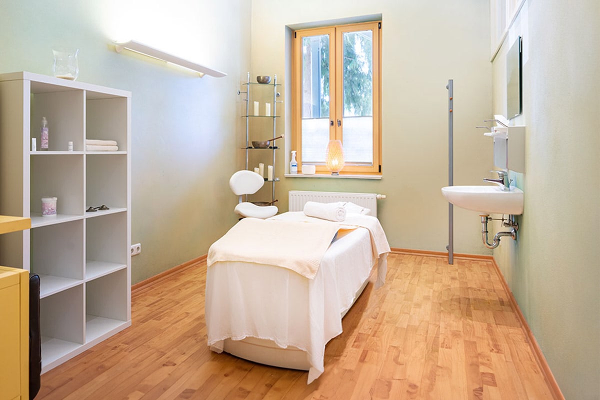Lichtdurchfluteter Raum mit Massageliege und Waschbecken im Preussen-Vital-Spa in Zinnowitz auf Usedom.