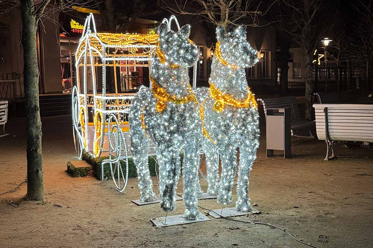 Beleuchtete Winterkutsche beim Inselglitzern in Zinnowitz, umgeben von Lichterglanz und gemütlicher Abendstimmung.